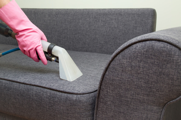 person cleaning upholstery